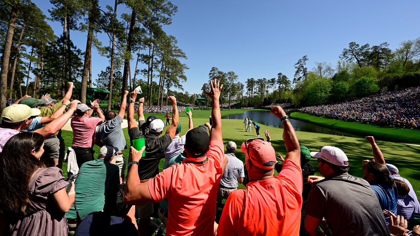 Patrons celebrate as Masters champion Tiger Woods birdies No. 16 during