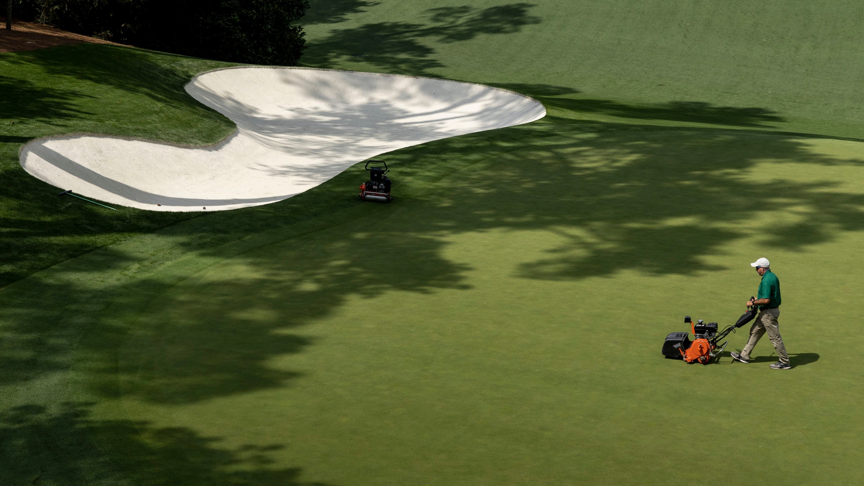 a-groundskeeper-tends-to-the-no-10-green-during-practice-round-3-at