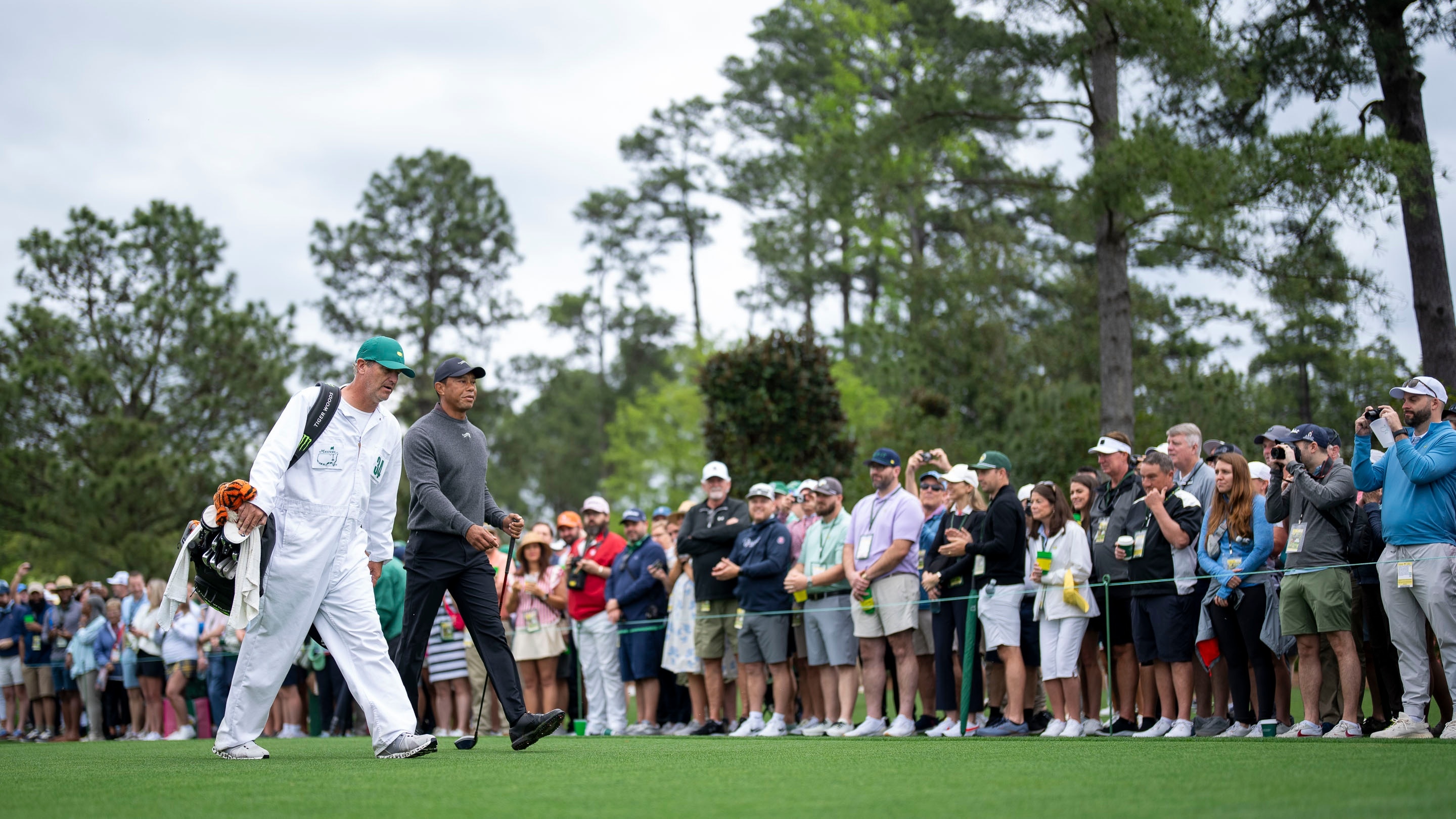 Masters patrons watch Masters champion Tiger Woods of the United States ...